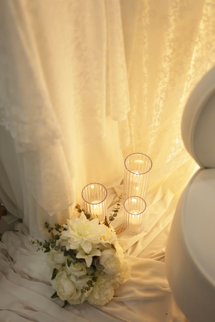 Soft lighting on wedding decor with candles and floral arrangement, creating a romantic ambiance.